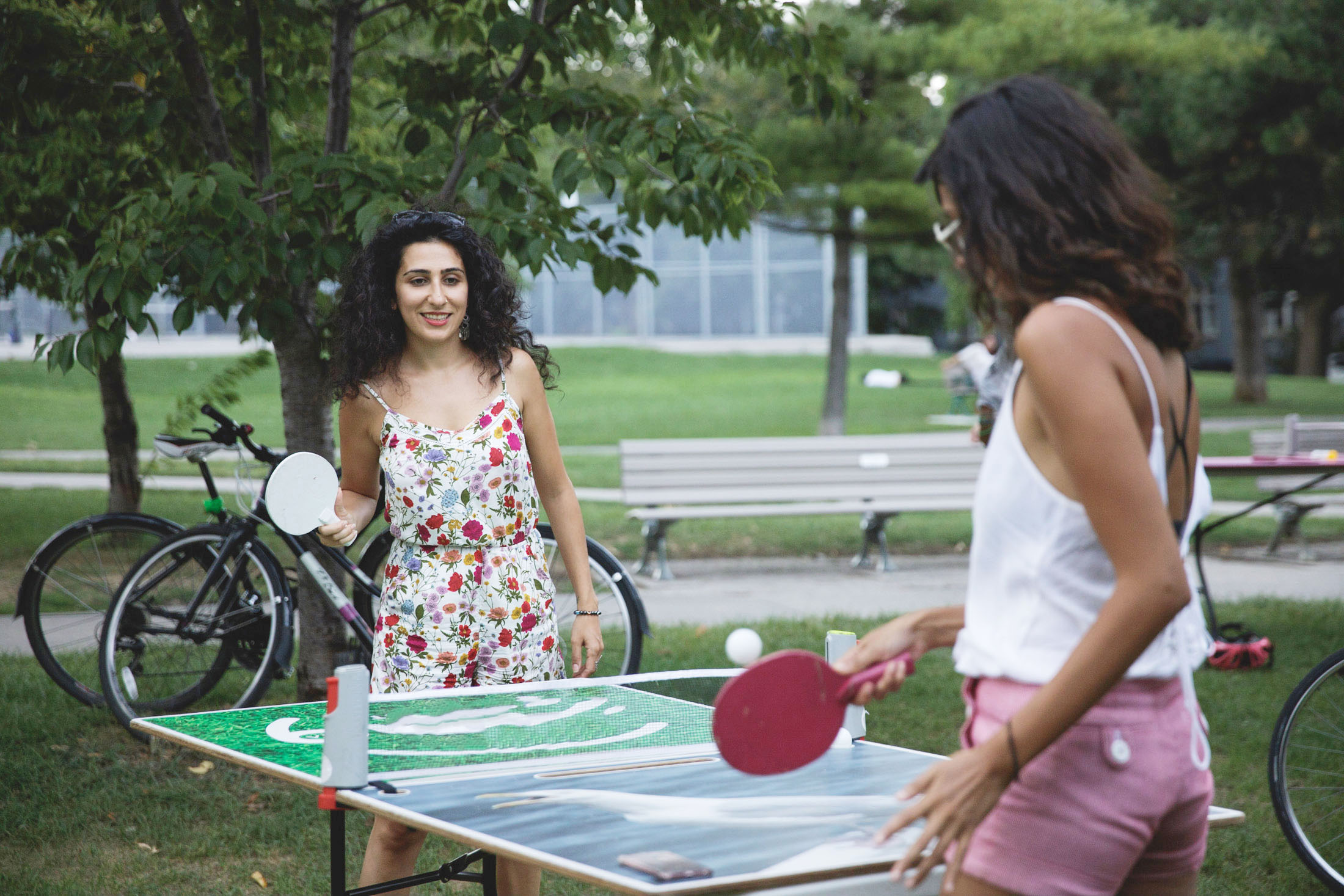 Two young women playing outdoor table tennis in Toronto
